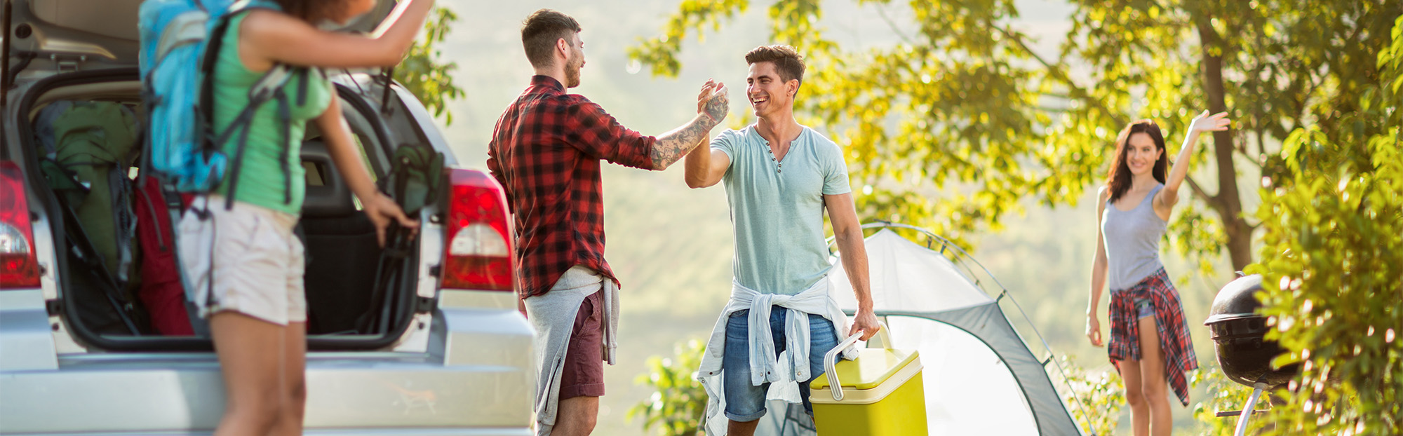 Amis partant camper avec voiture et matériel.