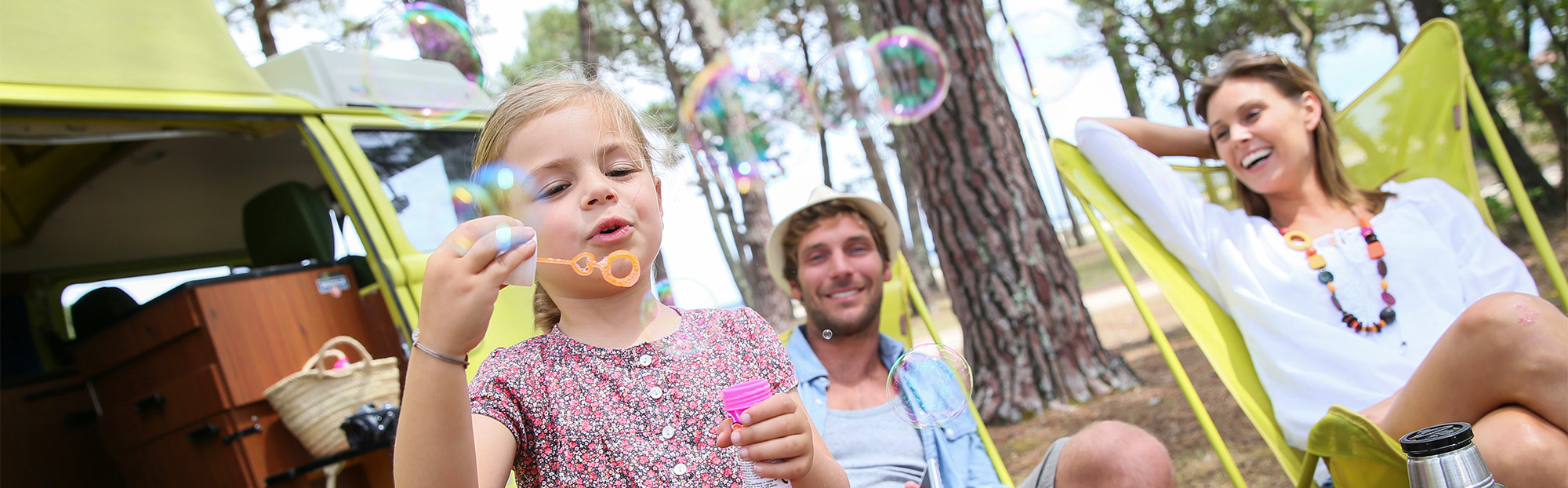 Enfant éclatant des bulles près d'un camping-car