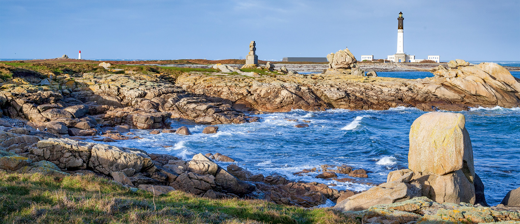 Phare sur une côte rocheuse avec mer agitée.